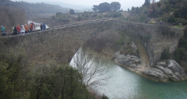 personas cruzando un puente de piedra